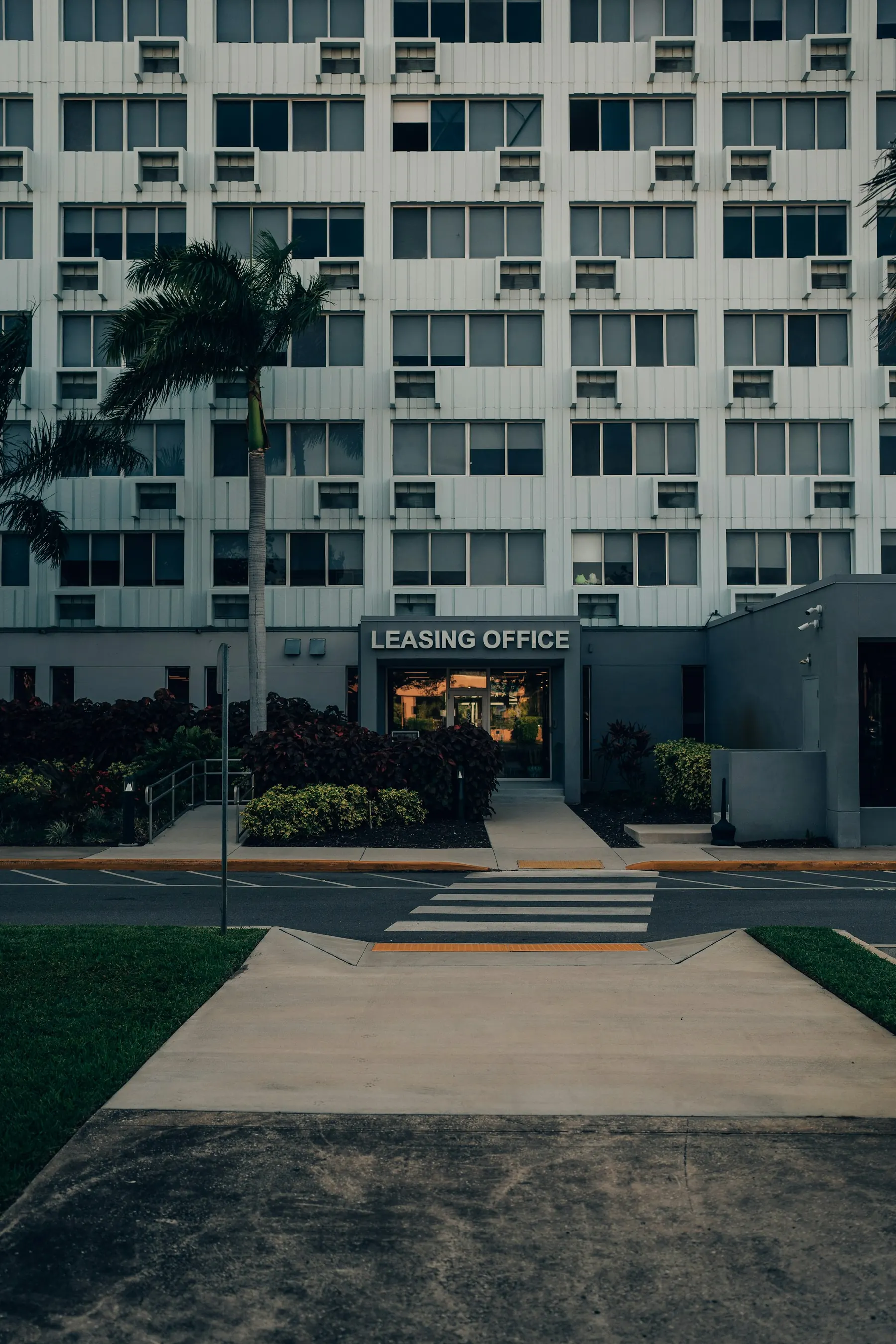 Mid-rise apartment building under palm trees